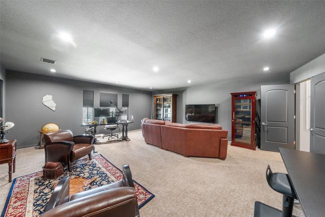 Spacious entertainment room with cozy seating. Ideal for relaxing or working from home, featuring modern lighting and neutral decor. | Image 27