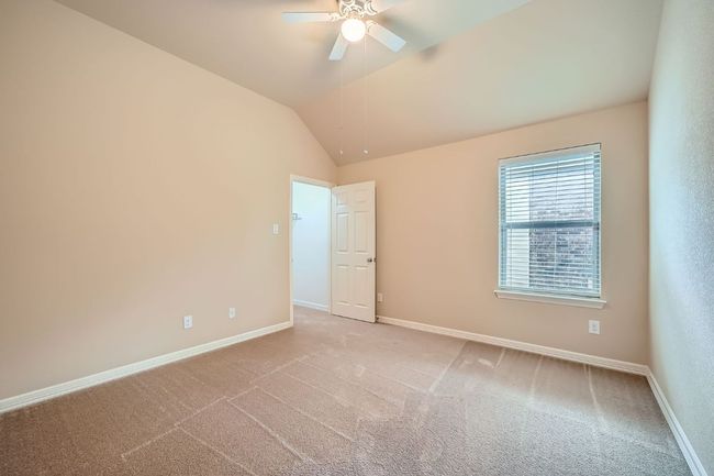 Carpeted empty room featuring ceiling fan and vaulted ceiling | Image 21
