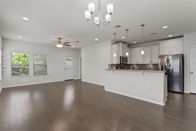 Kitchen with stainless steel appliances, a peninsula, light stone countertops, a ceiling fan, and recessed lighting | Image 7