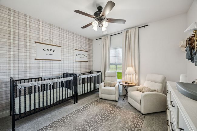 Bedroom with wallpapered walls, a ceiling fan, and a nursery area | Image 14