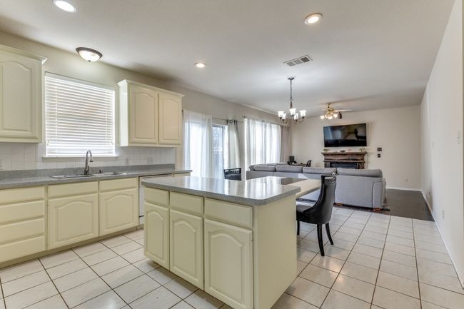 Kitchen featuring open floor plan, light tile patterned floors, a sink, and visible vents | Image 12