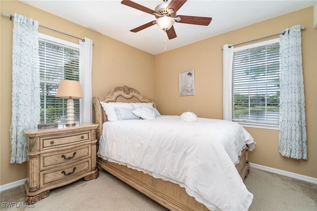 Bedroom with light carpet, baseboards, and a ceiling fan | Image 11
