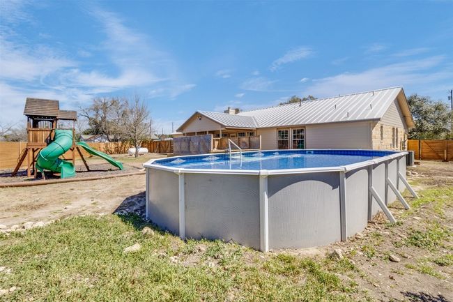 View of pool featuring a fenced in pool, a playground, and fence | Image 29