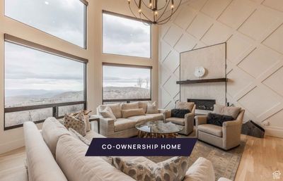 Living room featuring a mountain view, light wood-type flooring, and an inviting chandelier | Image 1