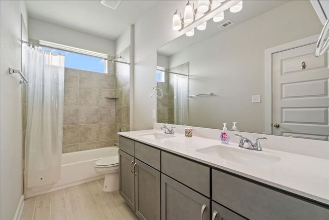 Full bathroom with shower / bath combo with shower curtain and double vanity | Image 15