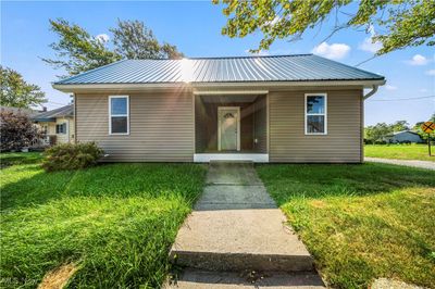 Bungalow-style home with covered porch and a front lawn | Image 1