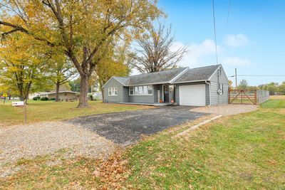 Ranch-style home featuring a front lawn and a garage | Image 2