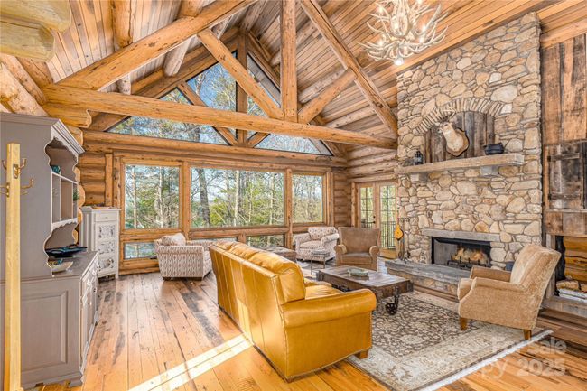 The massive windows in this space create a breathtaking connection to the outdoors, flooding the room with natural light. These expansive windows offer winter views of the lake and mountains. The ever-changing scenery enhances the home's serene and inviting atmosphere. | Image 15