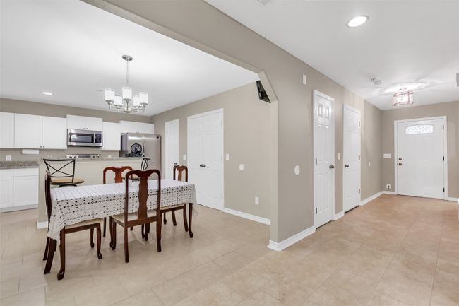 Dining space featuring a chandelier, light tile patterned floors, and recessed lighting | Image 6