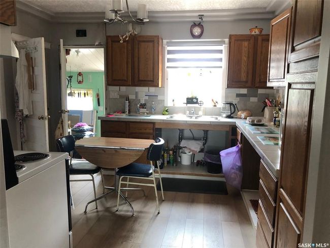 Kitchen with range, light countertops, decorative backsplash, light wood finished floors, and a textured ceiling | Image 19