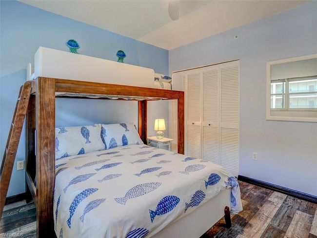 Bedroom featuring dark wood-style flooring, ceiling fan, and a closet | Image 30