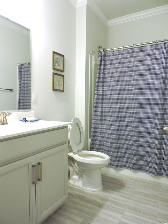 Bathroom featuring crown molding, shower / tub combo, vanity, and toilet | Image 28