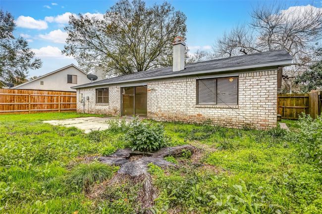 Another view of the backyard showcases its potential for customization. With mature trees and a fenced perimeter, this outdoor space offers a peaceful retreat to enjoy nature or create your ideal setup. | Image 24