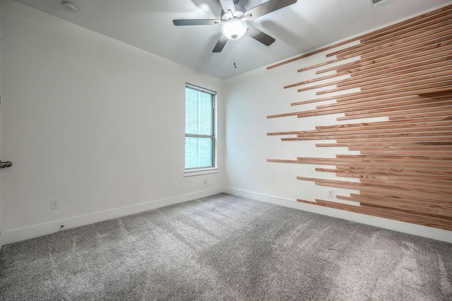 Carpeted spare room featuring ceiling fan, baseboards, and a smoke detector | Image 25