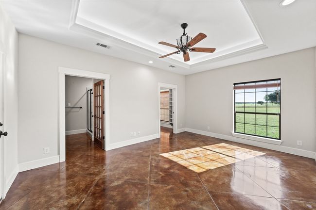 Empty room with a raised ceiling, a ceiling fan, recessed lighting, and baseboards | Image 17