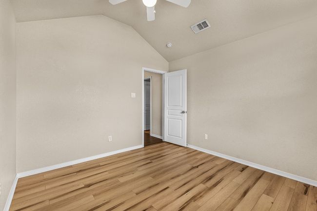Empty room with light wood-style flooring, vaulted ceiling, and a ceiling fan | Image 31
