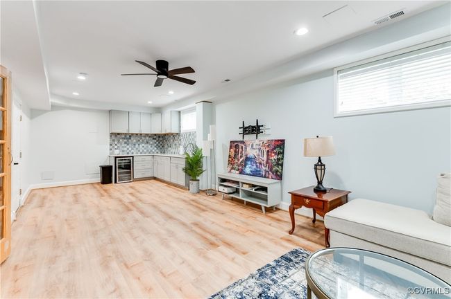 Living area featuring beverage cooler, visible vents, light wood-style floors, ceiling fan, and recessed lighting | Image 23