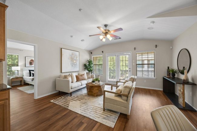 Living room with vinyl wood flooring with ceiling. French doors leading out to the balcony. | Image 5