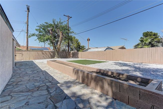 Fenced backyard with a patio | Image 31