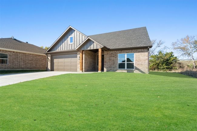 View of front facade with a front yard and a garage | Image 4
