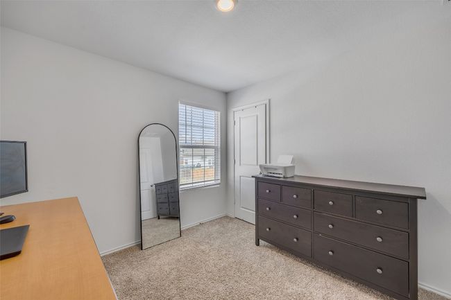 Bedroom with light colored carpet and an office area | Image 20