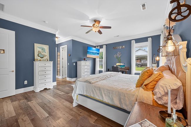 Bedroom with wood finished floors, crown molding, and a ceiling fan | Image 20