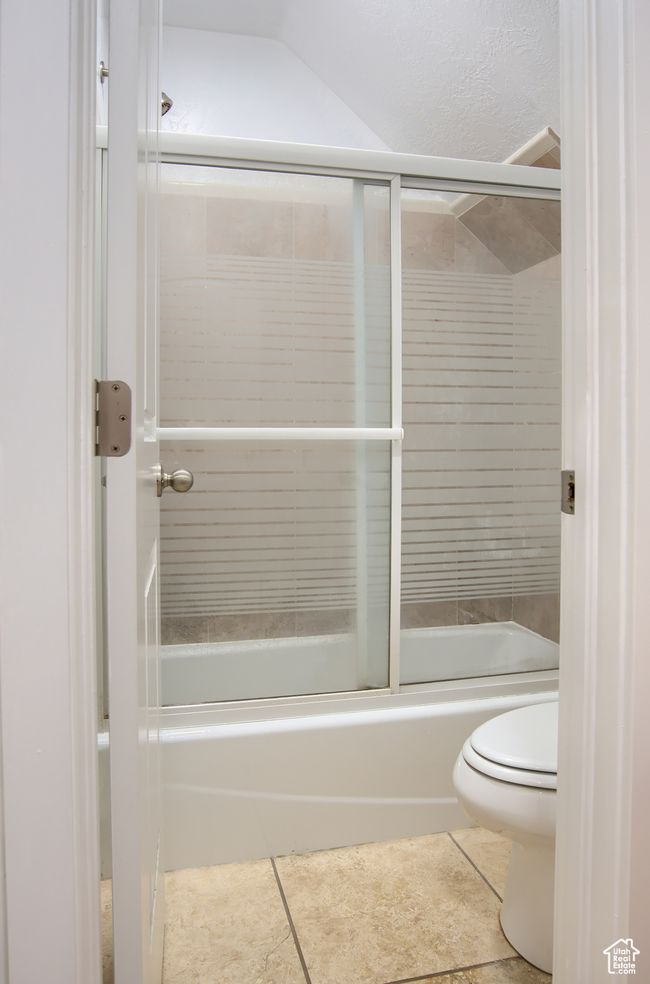 Bathroom featuring toilet, tile patterned flooring, and combined bath / shower with glass door | Image 18