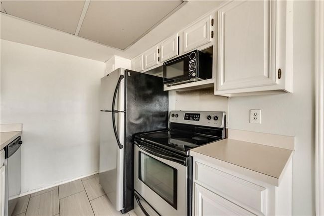 Kitchen with appliances with stainless steel finishes, light countertops, and white cabinetry | Image 7