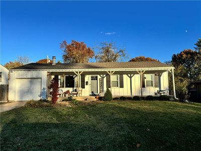 Single story home with a front lawn, a garage, and a porch | Image 1