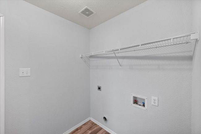 Laundry area featuring electric dryer hookup, new laminate flooring, and hookup for a washing machine | Image 35