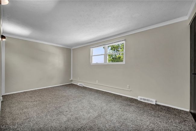 Carpeted empty room featuring ornamental molding and a textured ceiling | Image 12
