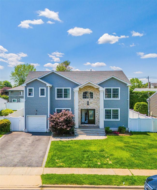 View of front facade with asphalt driveway, a garage, stone siding, and roof with shingles | Image 31