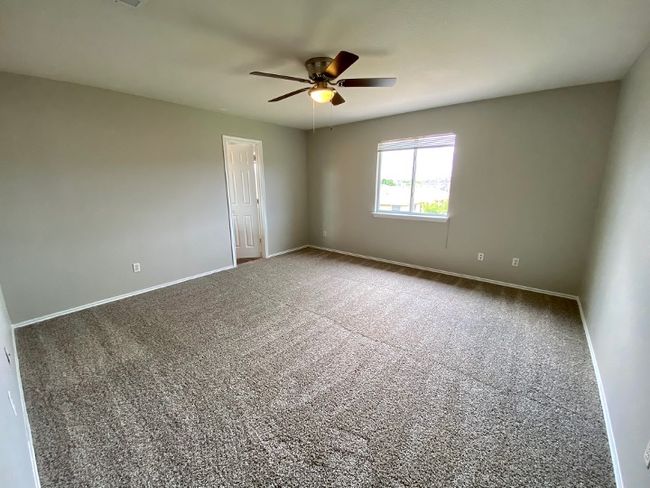 Carpeted spare room featuring a ceiling fan and baseboards | Image 21
