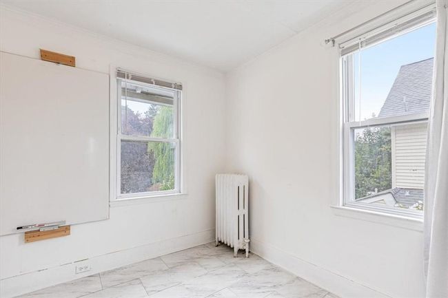 Tiled spare room featuring radiator heating unit and a healthy amount of sunlight | Image 17