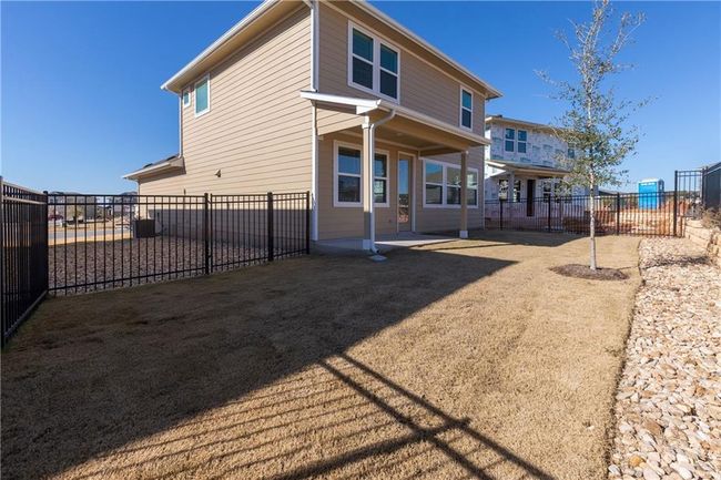Rear view of house with a fenced backyard and a patio area | Image 11