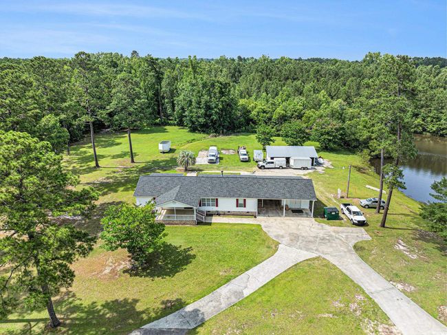 Aerial view of property and surrounding area with a heavily wooded area and a nearby body of water | Image 30