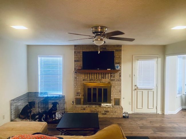 Living area with visible vents, a brick fireplace, a textured ceiling, wood finished floors, and baseboards | Image 6