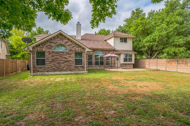 Back of house featuring a chimney, a yard, a patio area, and a fenced backyard | Image 26