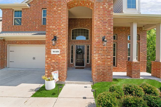 Property entrance featuring brick siding, an attached garage, and covered porch | Image 4