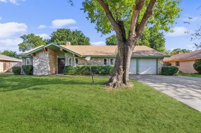 Single story home with a garage and a front lawn | Image 1