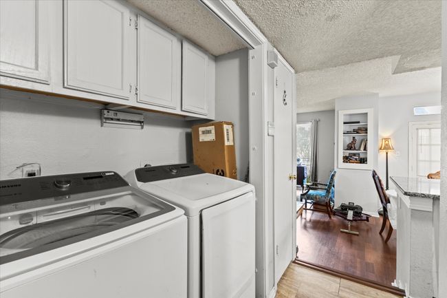 Laundry area with cabinet space, a textured ceiling, and separate washer and dryer | Image 12