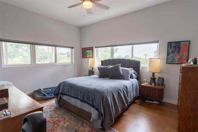 Bedroom with multiple windows, wood finished floors, and a ceiling fan | Image 15