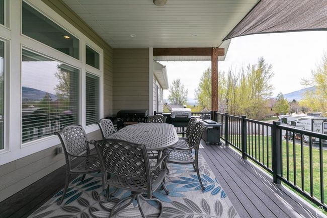 Wooden terrace featuring outdoor dining area and a grill | Image 66