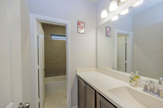 Full bathroom with vanity, tile patterned flooring, and tub / shower combination | Image 28