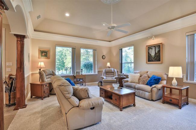 This large living room features crown molding, coffered ceiling with central rose, and plenty of windows to let the natural light in! | Image 13
