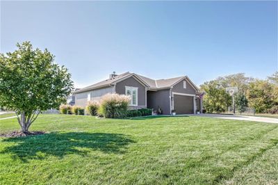 Ranch-style house with a front yard and a garage | Image 3