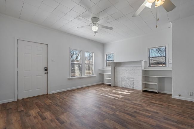 Unfurnished living room with ornamental molding, dark wood-type flooring, and ceiling fan | Image 5