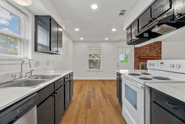 Kitchen with white range with electric cooktop, dishwasher, light wood finished floors, light countertops, and recessed lighting | Image 18