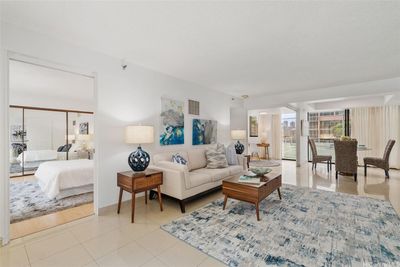 Open floor plan with living room, dining area, and 3rd bedroom with sliding walls that can also be used as a den or home office. Primary bedroom suite through doorway on the left in the photo. | Image 2