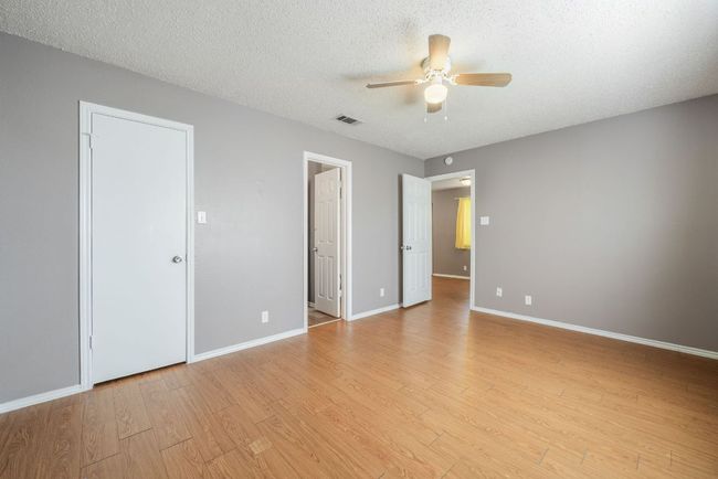 Unfurnished bedroom with light wood-style flooring, a textured ceiling, and a ceiling fan | Image 22